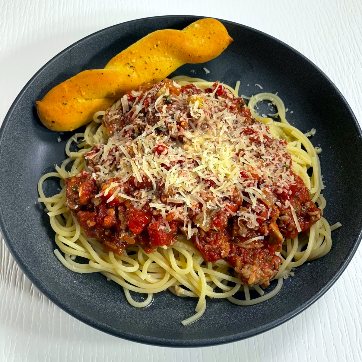 A plate of our favorite spaghetti. Topped with meat sauce and shredded parmesan cheese.